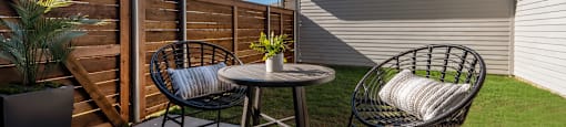 a patio with two chairs and a table on a patio
