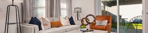 A modern living room with a grey couch, a white coffee table, and a floor lamp.