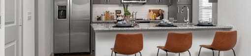 a kitchen with stainless steel appliances and a counter with three stools