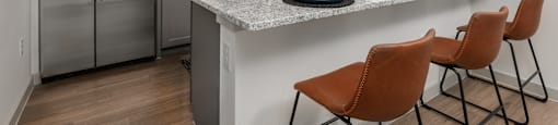 a kitchen with stainless steel appliances and a counter with chairs