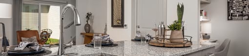 an open kitchen with granite counter tops and a sink