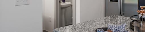 a kitchen with a granite counter top and a stainless steel refrigerator