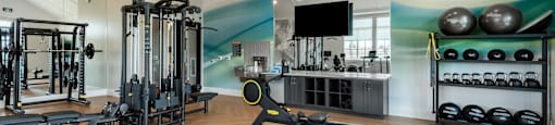 A gym with a variety of equipment including a rowing machine.