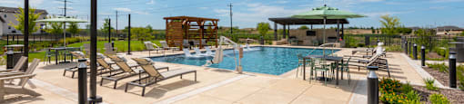 A pool area with sun loungers and a wooden structure.