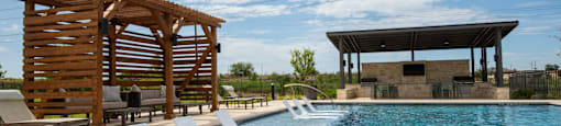 A pool with a wooden structure and lounge chairs.