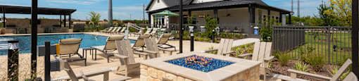 A poolside area with chairs and a hot tub.