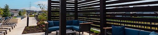 A patio with a blue couch and a wooden table.