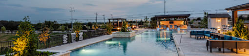 A large outdoor swimming pool with a long rectangular shape and a curved wall on one side.
