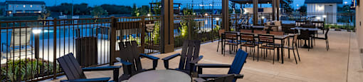 A patio with a table and chairs overlooking a pool.
