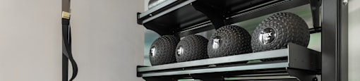 A set of kettlebells are on a rack in a gym.