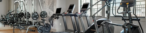 A gym with treadmills, elliptical machines, and other exercise equipment.