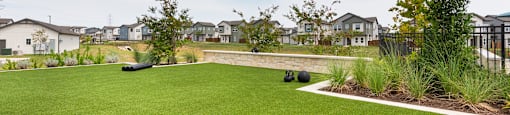 A green lawn in front of a row of houses.