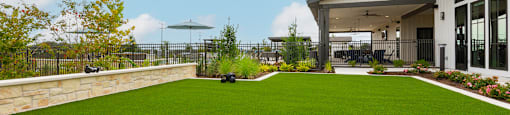 A modern house with a green lawn and a black cushion.