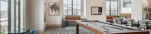 A room with a pool table and a bench.