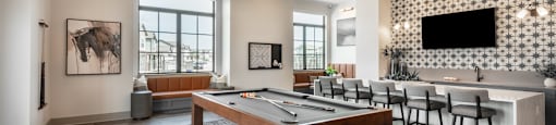 A room with a pool table and a television.