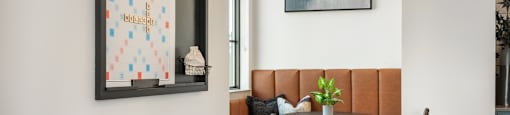 A dining area with a table set for two and a framed picture on the wall.