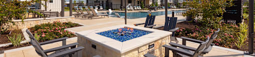 A pool surrounded by chairs and string lights.