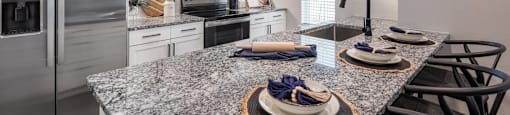 A kitchen with granite countertops and stainless steel appliances.