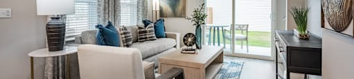 A living room with a white sofa, a wooden coffee table, and a ceiling fan.
