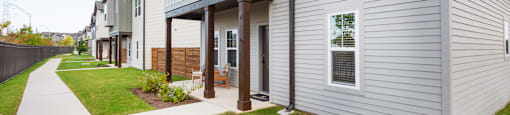 A long white house with a brown door and a small porch.