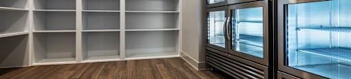 A room with a wood floor and a wall of empty shelves.
