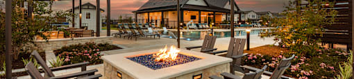 A backyard with a fire pit and chairs.