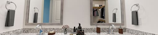 a bathroom with two sinks and two mirrors