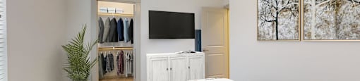 a bedroom with a bed and a tv in the corner
