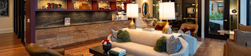 A living room with a grey couch and a wooden floor.