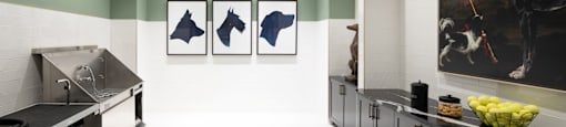A kitchen with a large painting of a horse and rider on the wall.