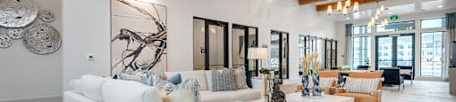a living room with white couches and a rug
