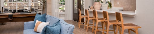 a living room with a blue couch and a table with chairs  at Hayden on West Ave, San Antonio