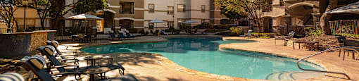 a swimming pool with chairs and a building in the background  at Hayden on West Ave, San Antonio