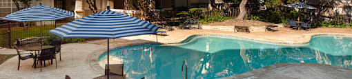 a swimming pool in front of a hotel with an umbrella  at Hayden on West Ave, San Antonio, TX