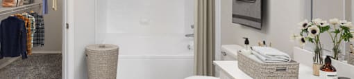a bathroom with a white toilet next to a white bathtub with a shower curtain  at Hayden on West Ave, San Antonio