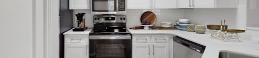 a kitchen with white cabinets and stainless steel appliances  at Hayden on West Ave, San Antonio, TX