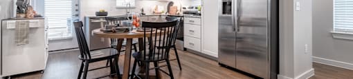 A kitchen with a table and chairs in the middle of it.