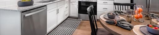 A modern kitchen with white cabinets and stainless steel appliances.