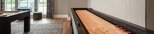 A pool table with a television mounted on the wall.
