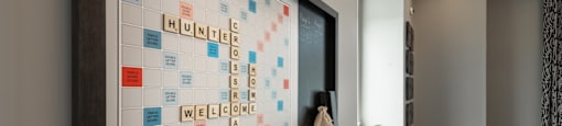 A framed board game with the words "Hunter" and "Welcome" spelled out on it.