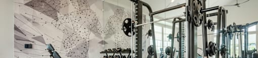 A gym with a wooden floor and a wall with a black and white geometric pattern.