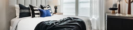 A bedroom with a large bed and a painting on the wall.