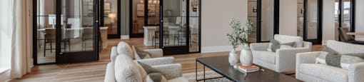 A modern living room with a glass door wall and a black coffee table.