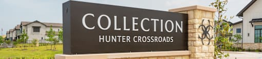 A sign for Collection Hunter Crossroads stands in front of a building.