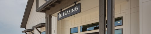 The front of a building with a leasing sign on it.