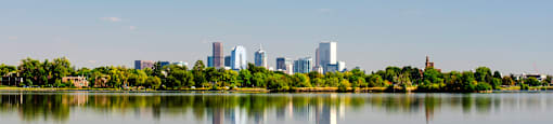 A city skyline is reflected in a body of water.