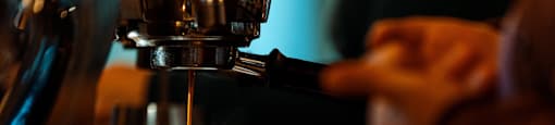 A person is making a cup of coffee using a coffee machine.