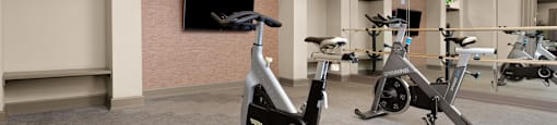 a gym with exercise bikes and a tv