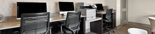 a computer room with desks and chairs and monitors