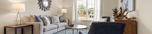a living room with a couch and a chair and a ceiling fan